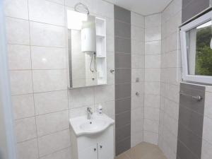 a white bathroom with a sink and a mirror at Apartman Maida in Blagaj