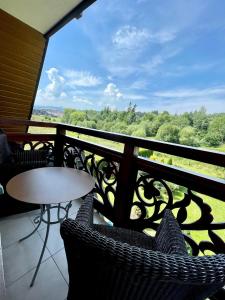 a balcony with a table and chairs and a view at Sarenka in Białka Tatrzańska