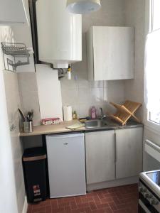 una pequeña cocina con armarios blancos y fregadero en Orléans 1er proche gare et centre T2 bis en Orléans