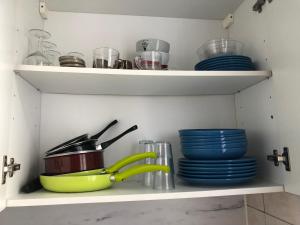 a kitchen shelf with dishes and bowls and plates at Orléans 1er proche gare et centre T2 bis in Orléans