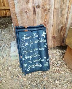 a sign sitting on the ground next to a wooden wall at Güneitzblick in Clenze