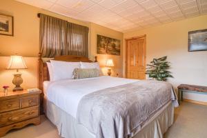 1 dormitorio con 1 cama grande en una habitación en Pine Ridge, Log Home with Lake View and Backyard, en Invermere