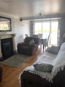 a living room with a bed and a couch and a table at Centrally located coastal townhouse Belmullet in Belmullet