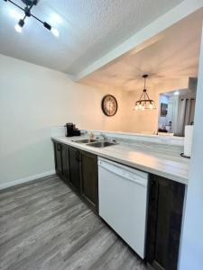 a kitchen with a counter and a clock on the wall at Nakiska, 2 Bed 1 Bath with Mtn Views in Canmore