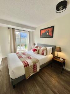 a bedroom with a large bed and a window at Nakiska, 2 Bed 1 Bath with Mtn Views in Canmore