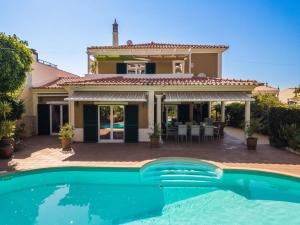 a house with a swimming pool in front of a house at Villa Ferragudo, Piscina e Mesa de Bilhar! in Ferragudo