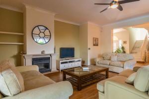 a living room with couches and a tv and a fireplace at Villa Ferragudo, Piscina e Mesa de Bilhar! in Ferragudo