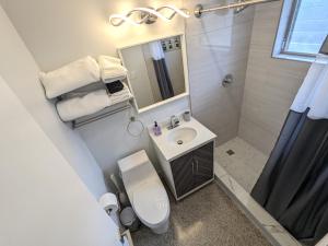 un bagno con lavandino, WC e specchio di Paradise Awaits! Beach, King Bed, Private Yard & Workspace a Deerfield Beach Altre 24 foto