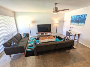 un soggiorno con un divano e un tavolo di Paradise Awaits! Beach, King Bed, Private Yard & Workspace a Deerfield Beach