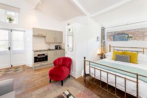a bedroom with a bed and a red chair at The Old Parsonage in Farrington Gurney