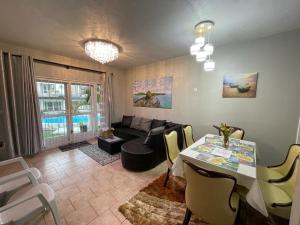 ein Wohnzimmer mit Tisch und Couch in der Unterkunft Your Holiday Home in Grand-Gaube