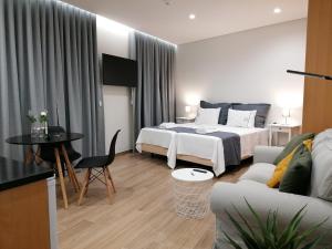 une chambre d'hôtel avec deux lits et un canapé dans l'établissement Apartments Madeira Funchal City, à Funchal