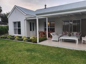 a white house with a patio with a table and chairs at Margie's Place in Swellendam