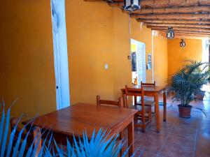 2 Tische und Stühle in einem Zimmer mit gelben Wänden in der Unterkunft ALOHA LINA in Máncora