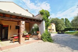 a building with an archway and benches on a driveway at Country Home CA' ISIDORA in Lazise