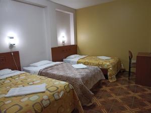 Una habitación de hotel con tres camas en una habitación. en Tamaris Hotel, en Chiclayo