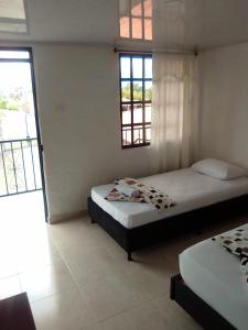 - une chambre avec 2 lits et 2 fenêtres dans l'établissement Finca Hotel La Marina, à Quimbaya