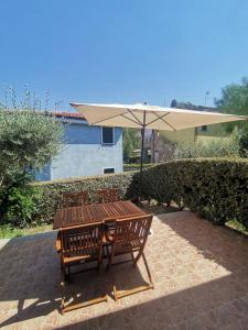 Santa MariaにあるSardegna Holiday houseの木製テーブルと椅子(傘付)