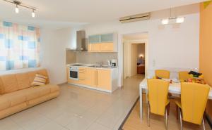 una cucina e un soggiorno con tavolo e sedie gialle di Room in Apartment - Cosy and modern family apartment for 4 a Promajna