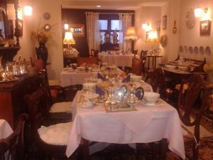 uma sala de jantar com mesas com toalha de mesa branca em Ben View Guesthouse em Clifden