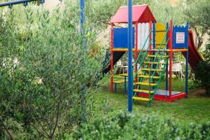 un parco giochi con uno scivolo colorato in un cortile di Room in Apartment - Cosy and modern family apartment for 4 a Promajna