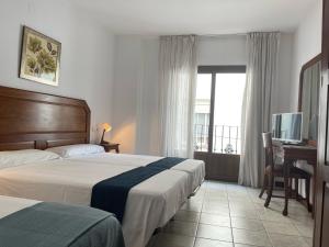 Postel nebo postele na pokoji v ubytování Hotel Al-Andalus