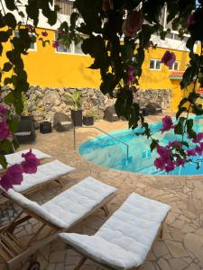 two white lounge chairs and a swimming pool at La Finquita - Adeje in Adeje