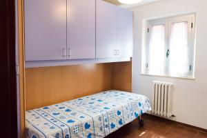 a small bedroom with a bed and white cabinets at N255 - Numana, trilocale con aria condizionata in Marcelli