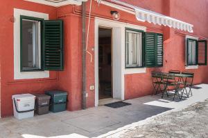 a red building with chairs and a table and windows at N255 - Numana, trilocale con aria condizionata in Marcelli