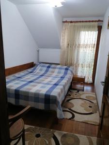 a bedroom with a bed with a blue and white blanket at Casa Tinu in Cenad
