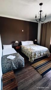 a bedroom with two beds and a chandelier at pousada canarinho in Tiradentes