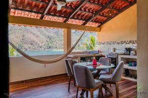 a dining room with a table and chairs and a large window at Casa Berita in Yelapa