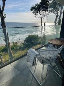 una silla, una mesa y vistas a la playa en APARTAMENT 36 na klifie z widokiem na morze ADULTS ONLY, en Rewal