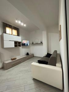 a white living room with a couch and a tv at La Casa sul Duomo in Terni