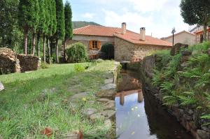 una casa y un río delante de una casa en Muiño das Cañotas, en O Lourido