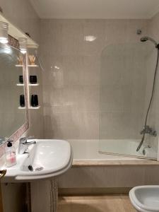 a bathroom with a sink and a shower and a tub at precioso apartamento con vistas al mar in Sanxenxo
