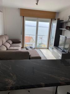 a living room with a couch and a flat screen tv at precioso apartamento con vistas al mar in Sanxenxo
