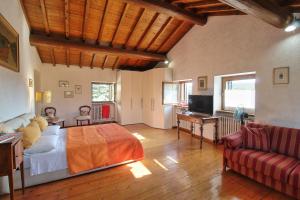 a bedroom with a bed and a living room with a couch at Country Home CA' ISIDORA in Lazise