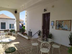 an outdoor patio with chairs and tables and a building at studio SUCCÈS in Pylos