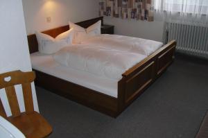 ein Schlafzimmer mit einem großen Bett mit weißer Bettwäsche und Kissen in der Unterkunft Ferienwohnung Reinstadler in Jerzens