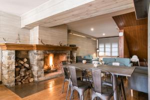 a dining room with a fireplace and a table and chairs at Hotel SNÖ Mont Romies in Salardú
