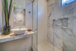 a bathroom with a sink and a glass shower at Hotel Água de Coco in Maceió