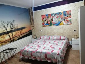 een slaapkamer met een bed en posters aan de muur bij La Vecchia Taverna B&B in Prignano Cilento