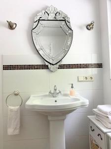 a bathroom with a sink and a mirror on the wall at Kuckuckswinkel Ferienwohnung Zarah in Schöna