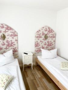 a room with two beds and a night stand at Kuckuckswinkel Ferienwohnung Zarah in Schöna