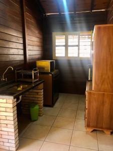 a kitchen with a counter and a microwave in a room at Estância Agnus Dei in Pirenópolis