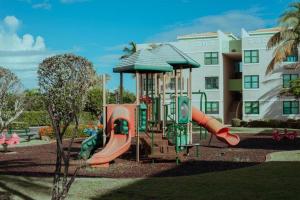 um parque infantil com um escorrega em frente a um edifício em AQUATIKA BEACH APT 1ST FL em Loiza