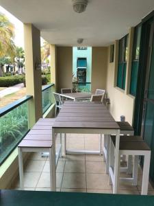 a wooden table and benches on a balcony at AQUATIKA BEACH APT 1ST FL in Loiza