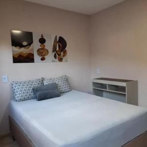 1 dormitorio con 1 cama blanca grande en una habitación en hospedagem recanto do sábia 1, en Caparaó Velho