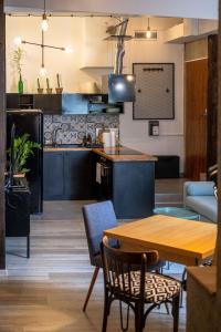 克拉科夫的住宿－Orzeszkowej PREMIUM Apartament，厨房以及带木桌和椅子的客厅。